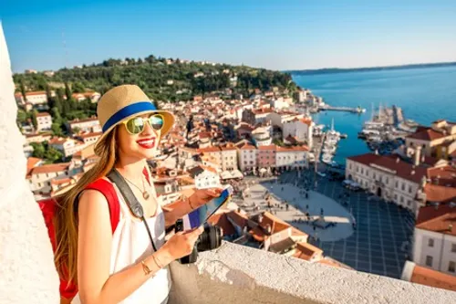 60999216 viajero femenino joven con una mochila roja y sombrero disfrutando de la vista desde la torre de geo